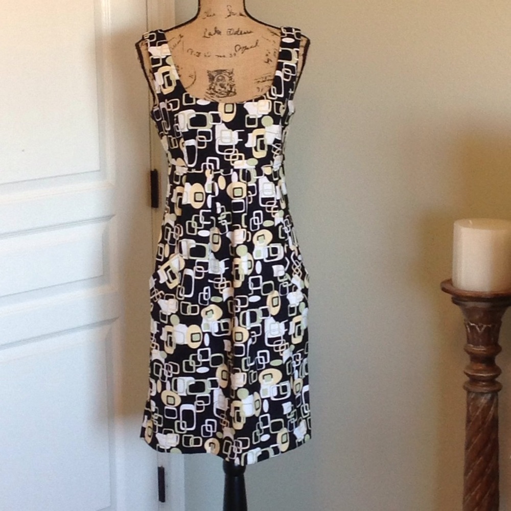 Sleeveless dress with pleats and pockets.